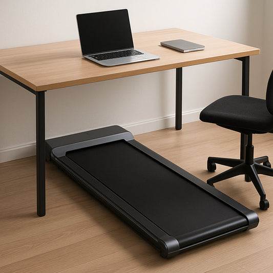 A sleek under‑desk walking pad treadmill tucked beneath a modern home office desk, showing the belt moving as a laptop sits on top. Alt: under desk walking pad treadmill in a home office.