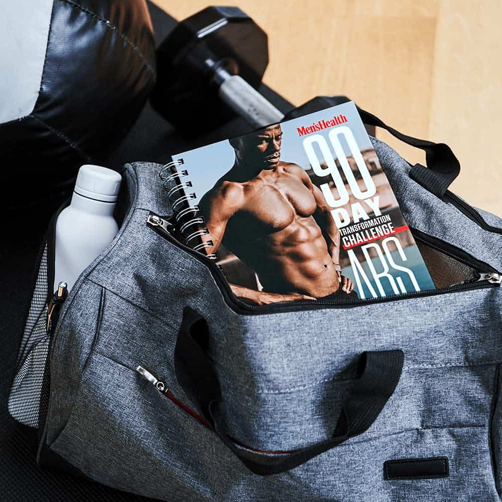 Gray duffel bag with a magazine titled '90 Day Transformation Challenge' and a water bottle.