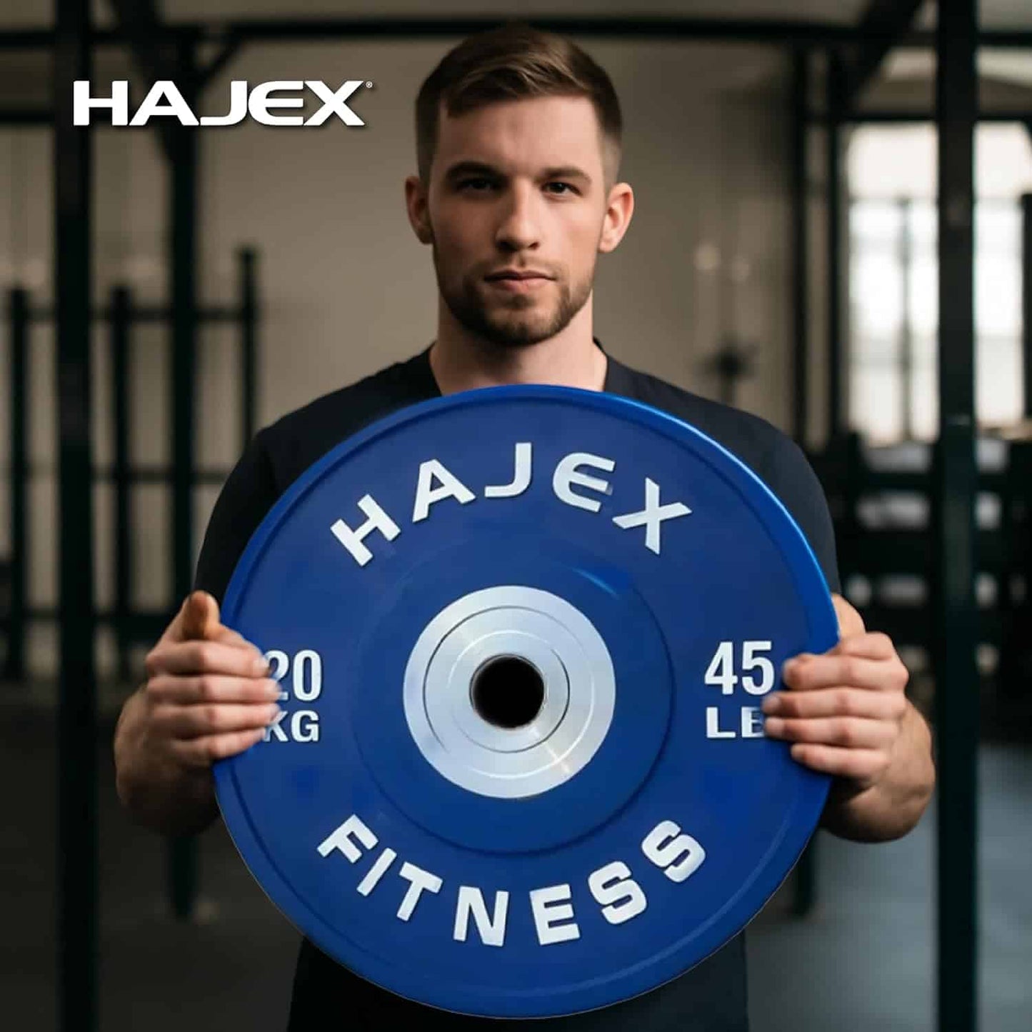 Man holding a blue weight plate with 'Hajex Fitness' branding in a gym setting.