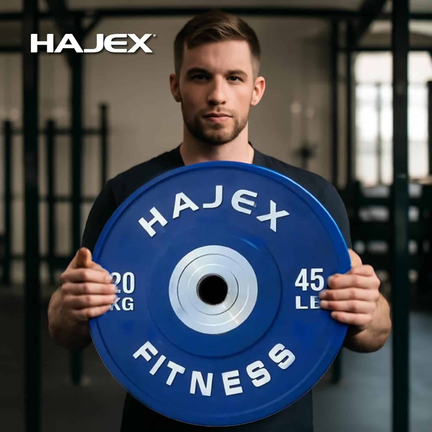 Man holding a blue weight plate with 'Hajex Fitness' branding in a gym setting.