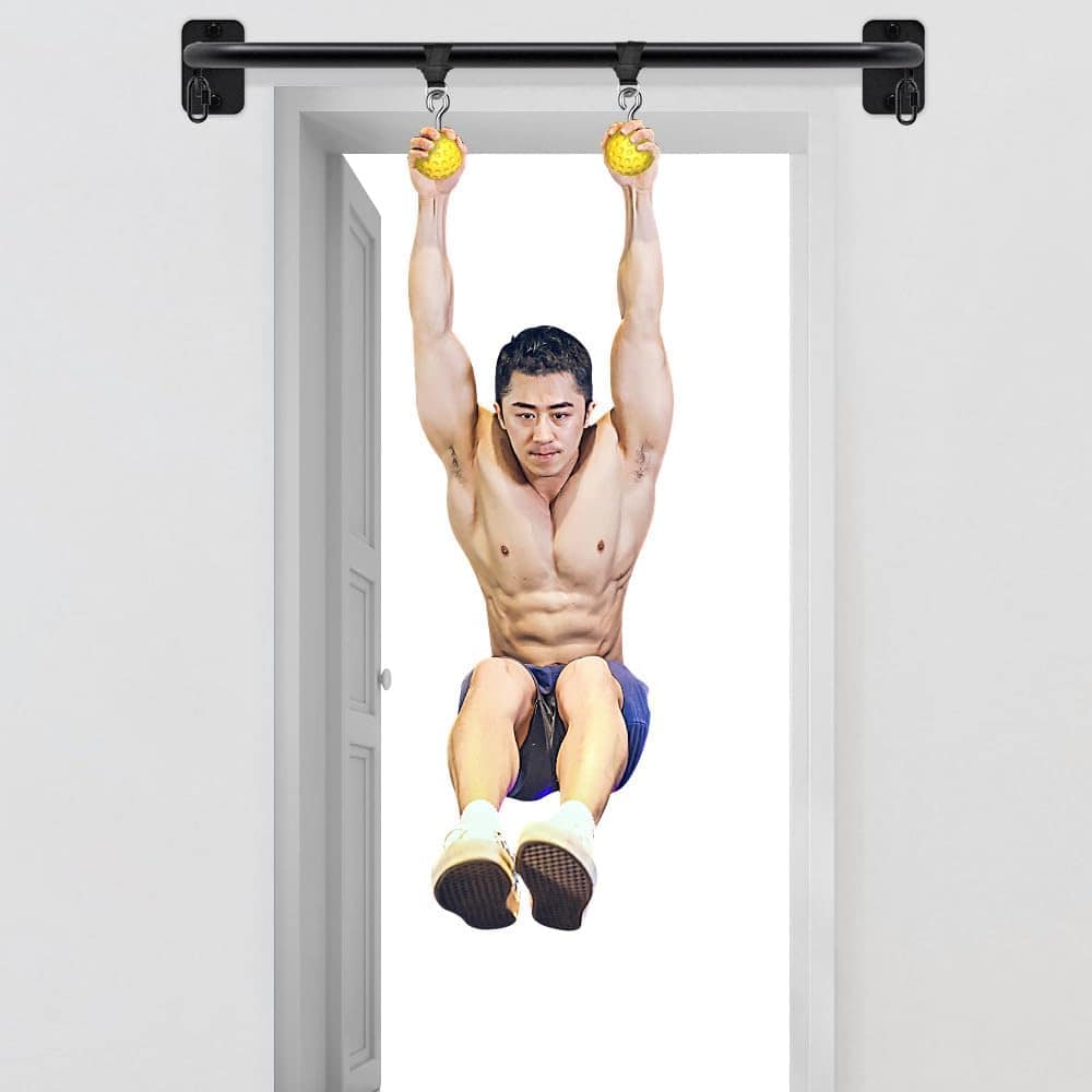 Person using a pull-up bar with resistance balls in a home setting