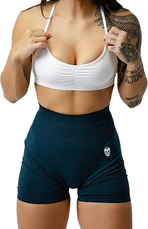 Person wearing a white sports bra and teal shorts with a brand logo.