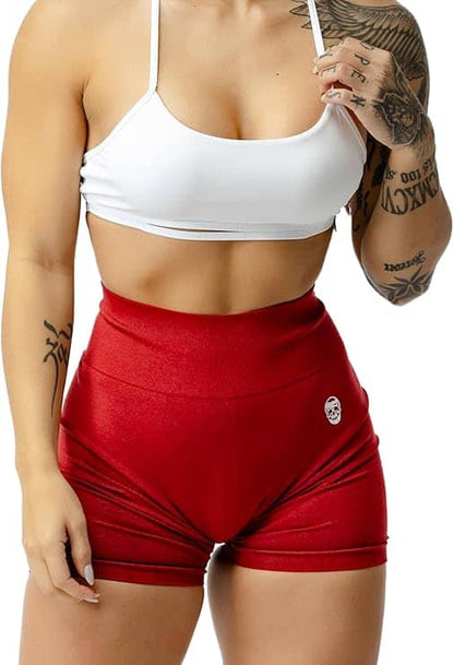 Person wearing a white sports bra and red shorts on a white background