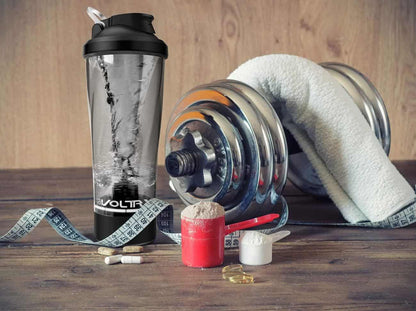 Fitness equipment including a shaker bottle, dumbbells, and protein powder on a wooden surface.