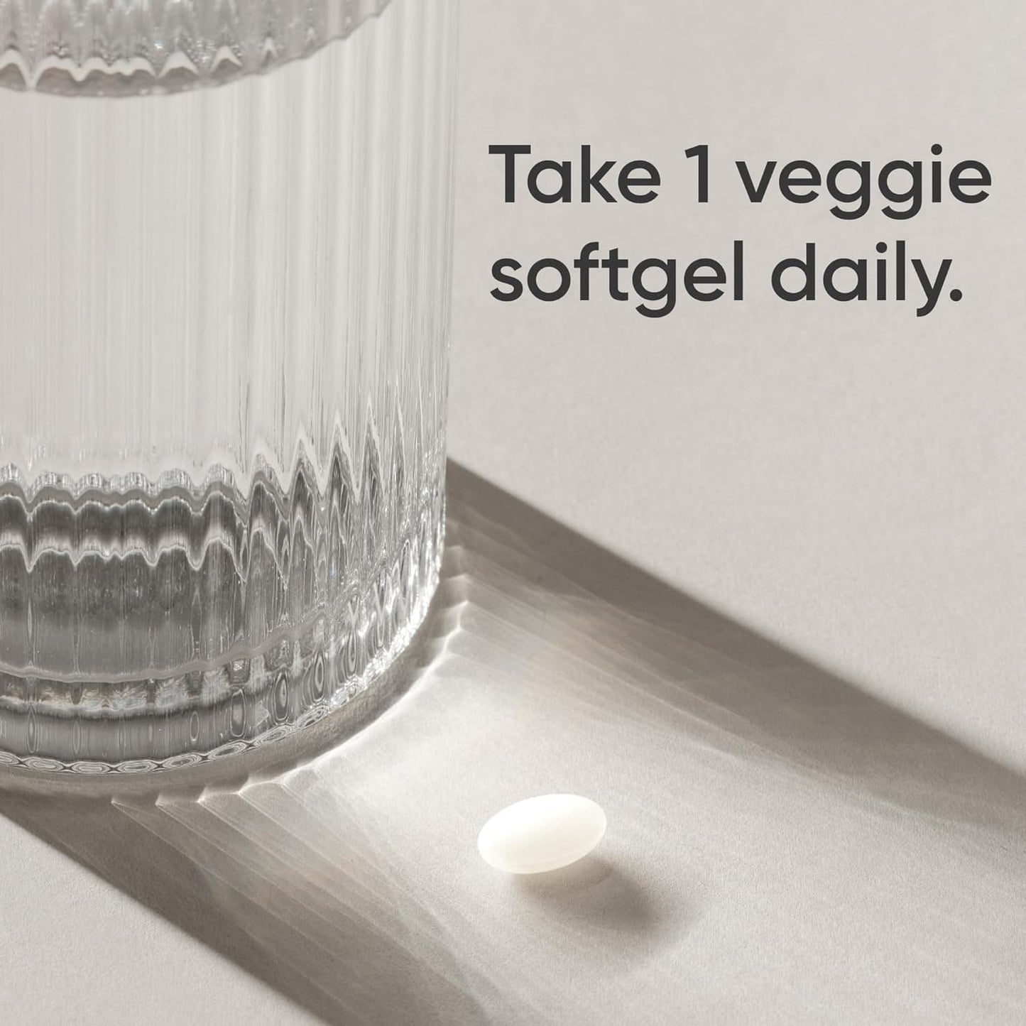 Veggie softgel next to a glass of water with text 'Take 1 veggie softgel daily.'