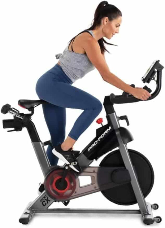 Woman exercising on a ProForm stationary bike against a white background